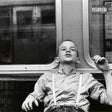 Black and white album cover with a child sitting on a bus, featuring a parental advisory label.