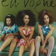 Three women sitting on a couch with 'En Vogue' album cover in the background