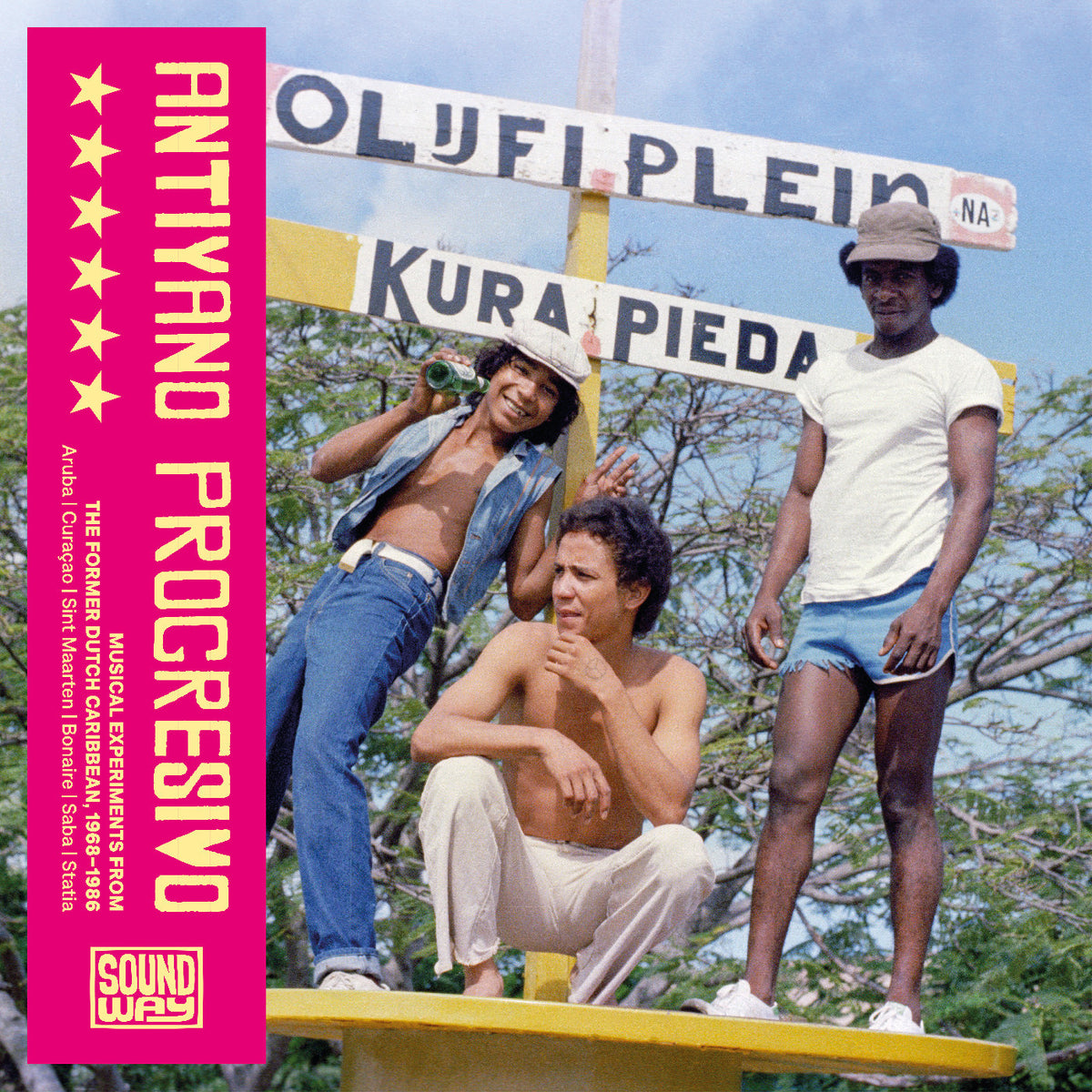Album cover for Antyano Progressivo by The Conker Music Ensemble, featuring three men posing outdoors in front of a signpost on a yellow platform, with a bright pink spine on the left.