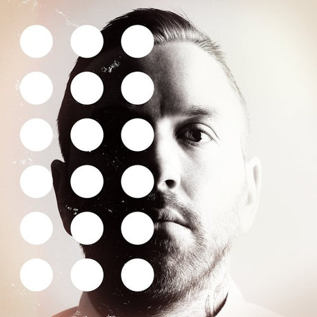 Man with a stylized face design featuring white circles on a light background