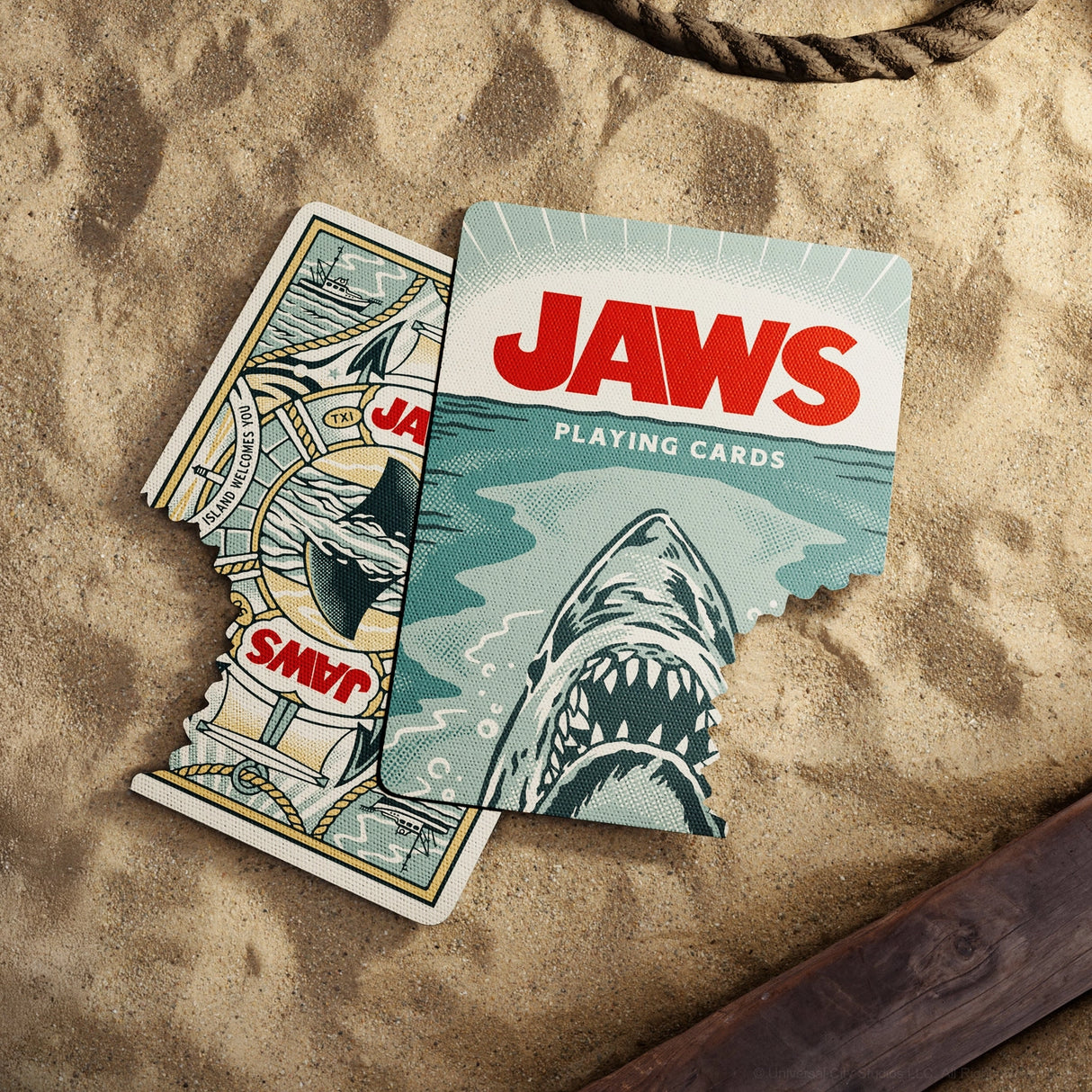 Jaws-themed playing cards on a sandy surface