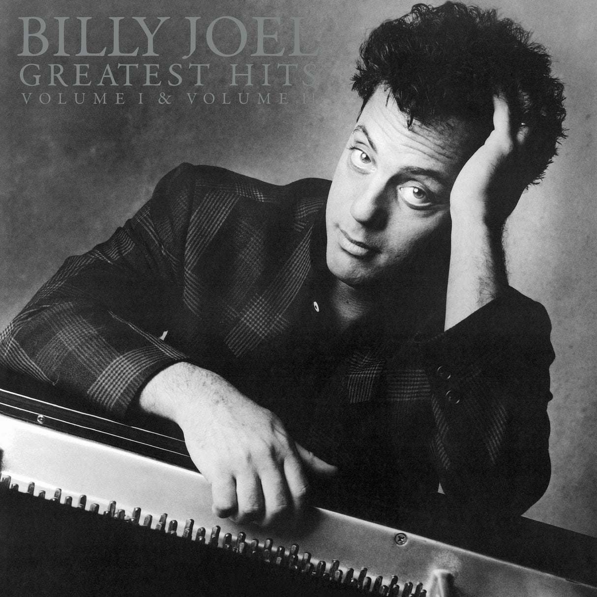 Album cover featuring Billy Joel with text 'Billy Joel Greatest Hits Volume I & Volume II' on a gray background.