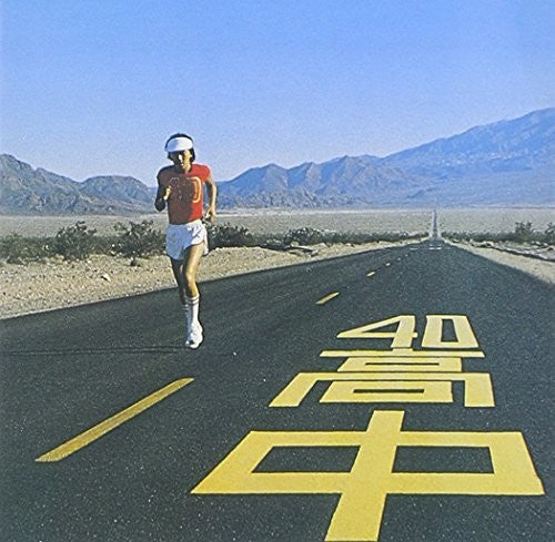 Person running on a desert road with mountains in the background