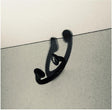 Black metal hook on a textured white surface