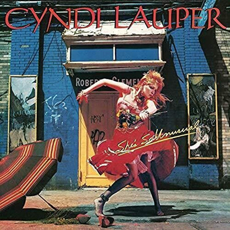 Album cover with a person in a red dress against a graffiti-covered wall, featuring the name Cynidi Lauper.