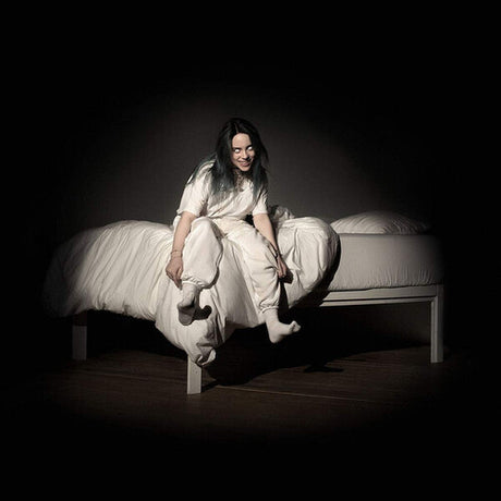 Person sitting on a bed in a dark room, wearing a white dress.