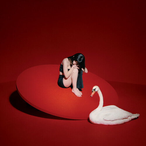 Woman sitting on a red platform with a white swan on a red background