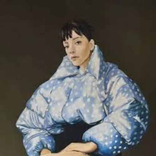 Person wearing a large blue puffer coat against a dark background
