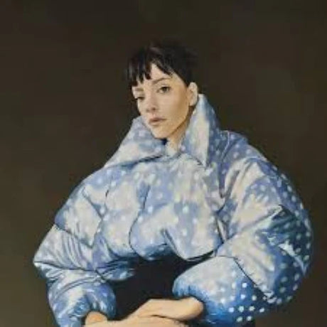 Person wearing a large blue puffer coat against a dark background