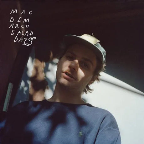 Album cover with a person wearing a cap and text 'Mac Demarco Salad Days' on a dark background