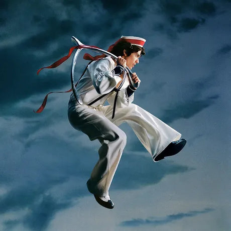 Person in a white uniform with a red ribbon against a blue sky