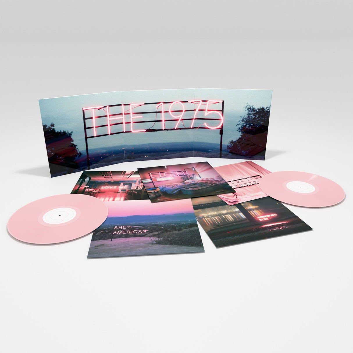 Vinyl record set with pink discs and cover featuring 'The 1975' on a white background