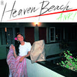 A vinyl record titled 'Heaven Beach' by Anri with a visual representation of a woman standing on a balcony at night, holding a flower, with the album title and artist name in stylized text.
