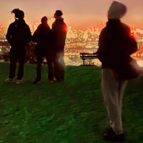 People silhouetted against a cityscape at sunset