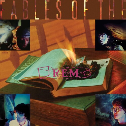 Album cover with open book, flames, and 'R.E.M.' logo on a wooden surface.