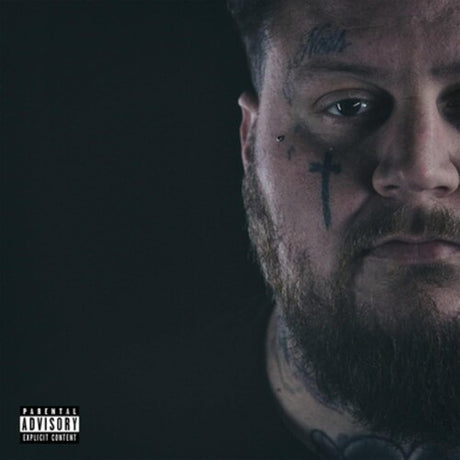 Close-up of a person with tattoos on a dark background, featuring a 'Parental Advisory Explicit Content' label.