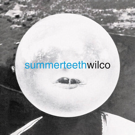 A vinyl record label with the text 'SUMMERTEETH WILCO' in blue font, against an image of a mouth-like opening with a blurred background.