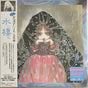 Vinyl record cover with an illustration of a person wearing a hooded garment on a textured background.
