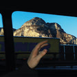 Hand holding a smartphone with a mountainous landscape in the background