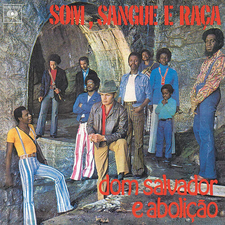 Album cover with a group of people in front of a stone archway, featuring text at the top and bottom.