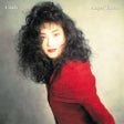 Person with curly hair wearing a red garment against a plain background