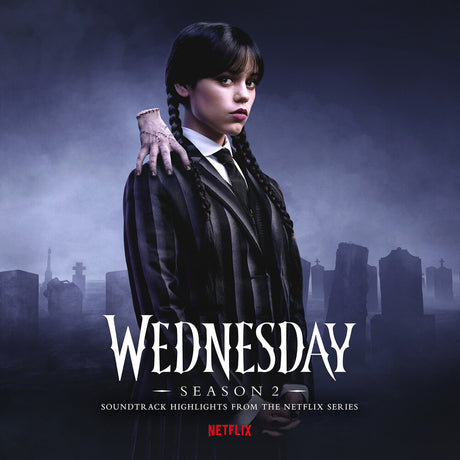 Promotional image for 'Wednesday' season 2 soundtrack with a character in a dark outfit against a foggy cemetery background.