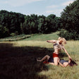Two people lying on a grassy field with trees in the background