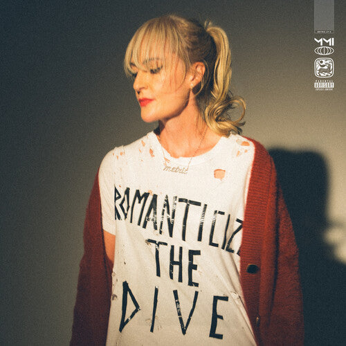 Person wearing a shirt with text, standing against a dark background