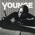 Person sitting at a table with 'Adrian Younge' branding in the background
