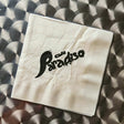Beige napkin with 'Cafe Paradiso' text on a textured surface