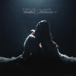 Album cover art for 'Tochet deluxe' featuring a silhouetted figure in a flowing white garment against a dark background with dramatic spotlighting and the title in white script at the top.