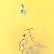 Person sitting on a bicycle against a yellow background