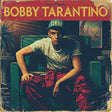 Album cover with a person sitting on a couch, featuring text and a vintage design.
