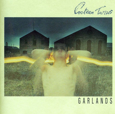 Album cover for 'Garlands' by Cocteau Twins featuring a blurred figure and buildings.