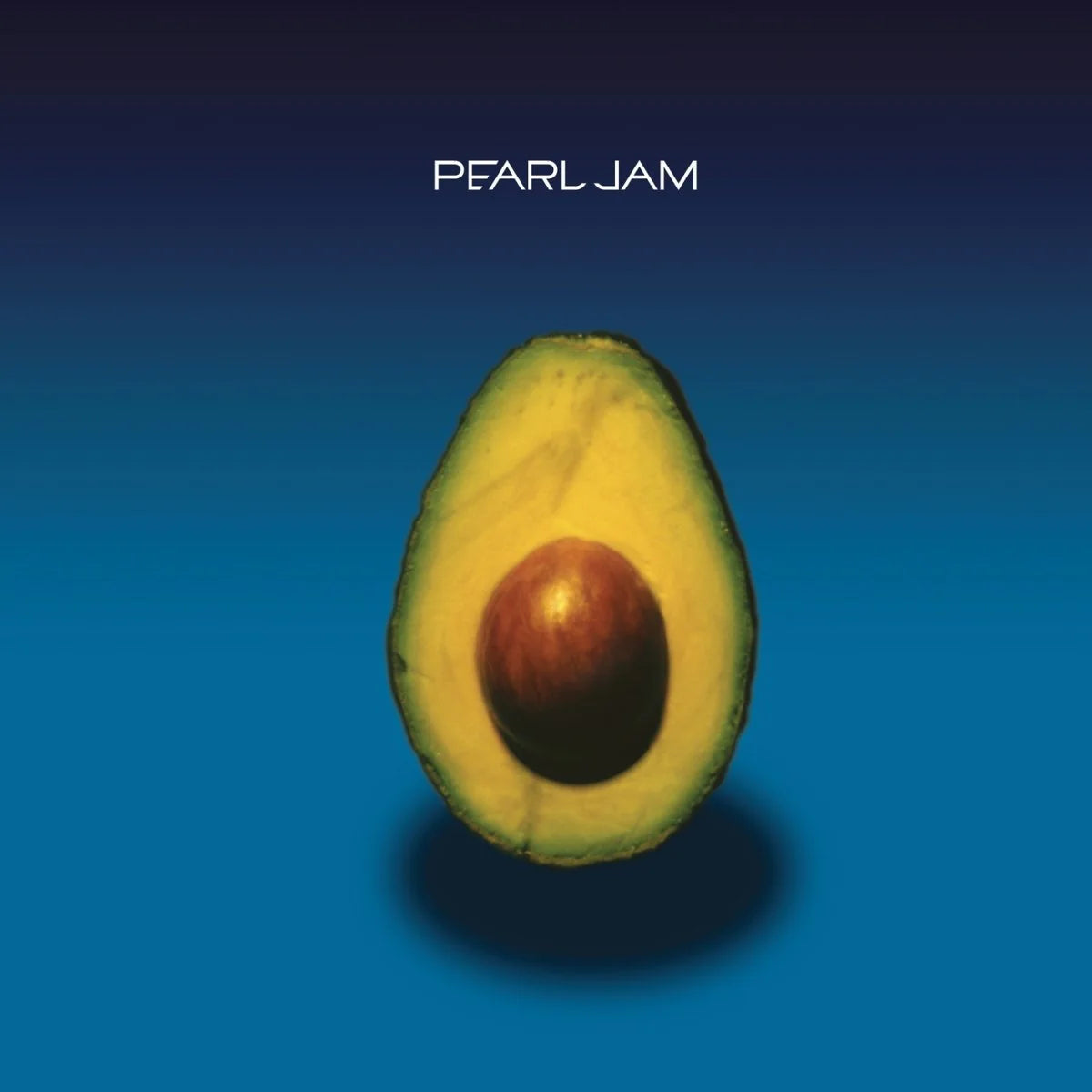 Avocado cut in half on a blue background with 'Pearl Jam' text above