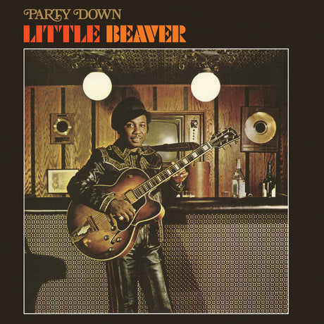 Album cover featuring a person playing guitar in a room with wood paneling and a television.