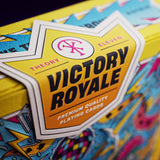 Close-up of a deck of 'Victory Royale' playing cards with colorful designs and a visible brand logo.