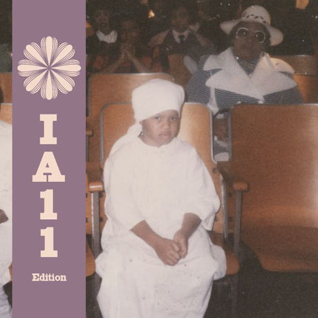 Person in white garment sitting in an auditorium with a purple border and 'IA11 Edition' text.