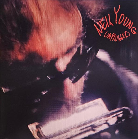 Album cover with a person playing harmonica, text 'Neil Young Unplugged' in red.