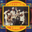 Album cover with a band in chef outfits posing around a pot, surrounded by colorful geometric patterns and text.