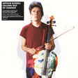 Person holding a colorful cello with album cover text on the left