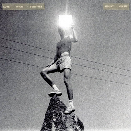 Person on a rock with a light source over their head against a power line background