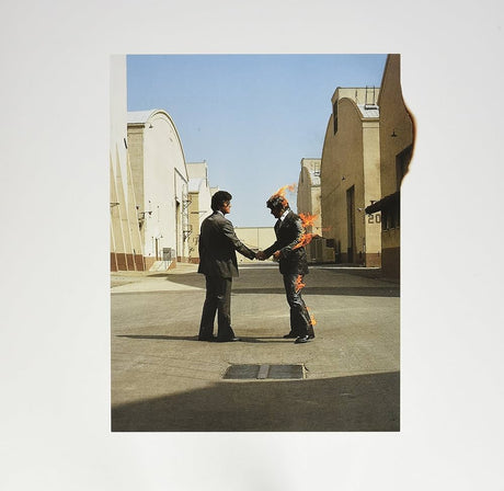 Two people shaking hands with one person on fire in an architectural setting