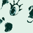 Pattern of black ink blots on a light green background