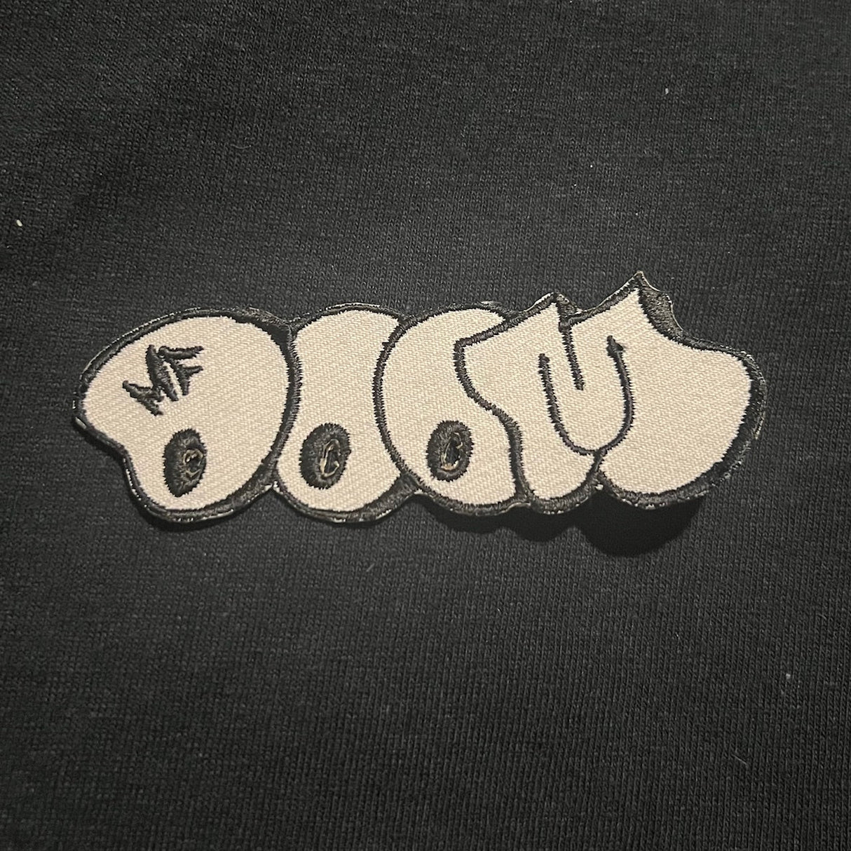 Textured patch with 'MF DOOM' logo on a black background
