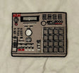 Embroidered patch of a music synthesizer on a beige fabric background