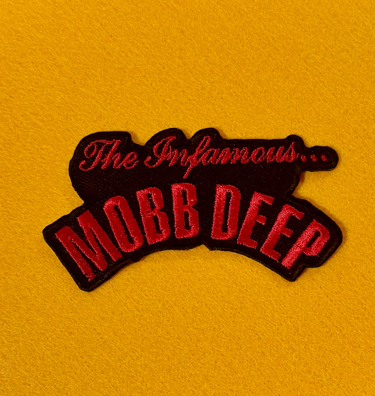 Embroidered patch with 'The Infamous Mobb Deep' text on a yellow background
