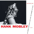 Album cover featuring a saxophone with a person holding it, black and white with red text.