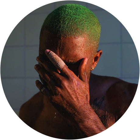 Person with green hair covering face with hand, against a tiled wall background