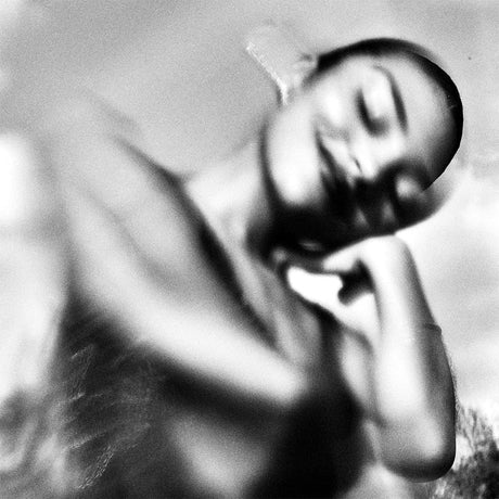 Black and white photo of a person lying on the ground with blurred background